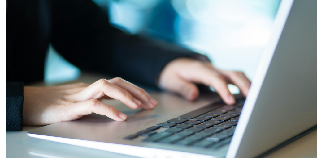 “professional working on laptop in clean office workspace”